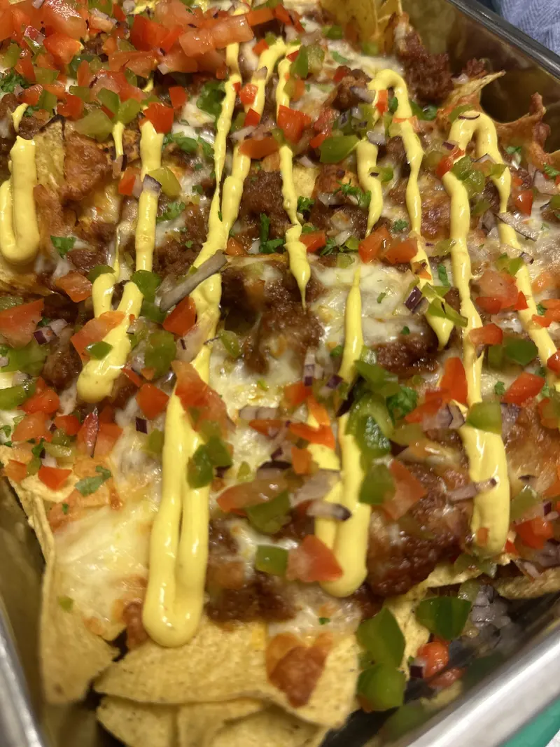 Nachos med kjøttdeig, ost, tomat og dressing i buffetkar